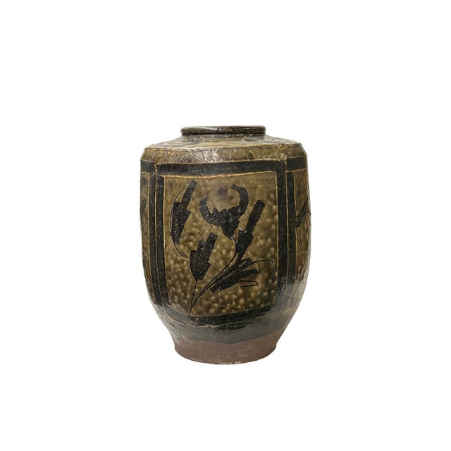 This ancient ceramic jar exudes a rustic charm, its weathered surface telling tales of centuries past. The vessel, crafted...