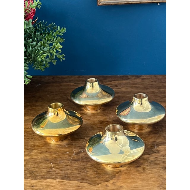 A refined set of four original Hein Studio solid brass candle holders, showcasing clean Scandinavian modern design with a...