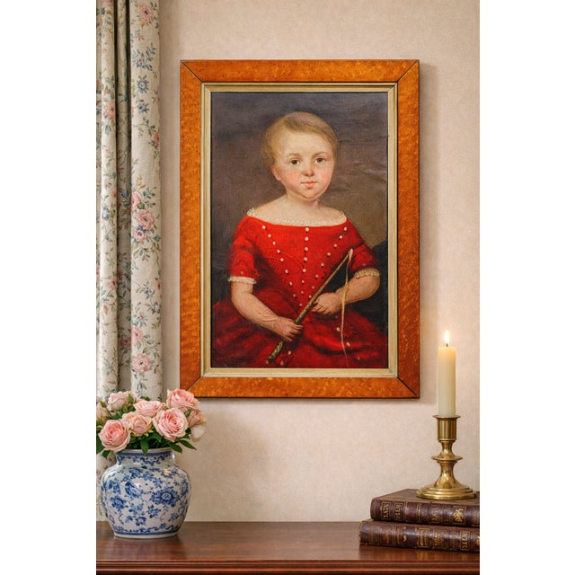 This antique oil painting is a striking portrait of a figure dressed in an opulent red gown adorned with delicate white...