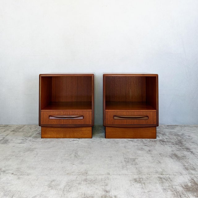 Each cabinet has an open storage compartment above a single drawer, fitted with the sculpted solid teak handle...
