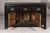 A black lacquered Qing Dynasty sideboard from the 19th century with rubbed edges, brass hardware, three drawers over two...