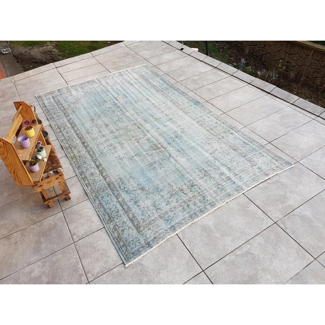 This is a vintage Turkish Oushak rug from the 1960s. The piece was hand-knotted.