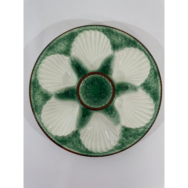 A striking antique French Faience Longchamp glazed majolica oyster plate with a vibrant green basket weave background and...