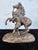 This expressive signed sculpture depicts a dramatic classical scene of a youthful figure restraining a rearing horse, a...