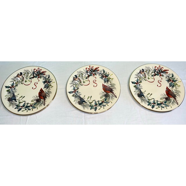 A beautifully preserved set of Lenox “Winter Greetings” plates, adorned with 24-karat gold and illustrated by Catherine...