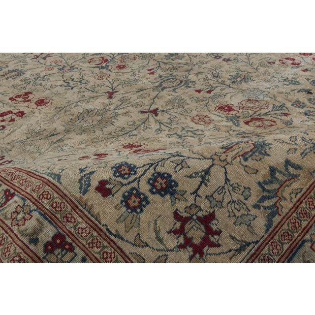 An early 20th century Northwest Persian Tabriz rug, the caramel field with a green palmette and delicate tracery vine...