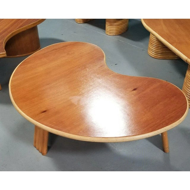Restored rattan and mahogany top Biomorphic coffee table with 3-strand rattan legs. Also commonly called an "amoeba" table...