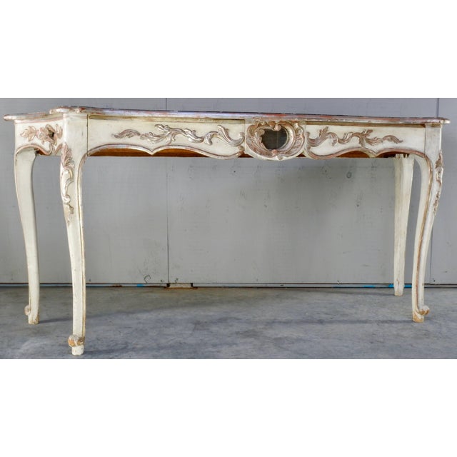 This is a beautiful hand-painted Italian console table with the base of white and silver gilt detail. The top has a trim...
