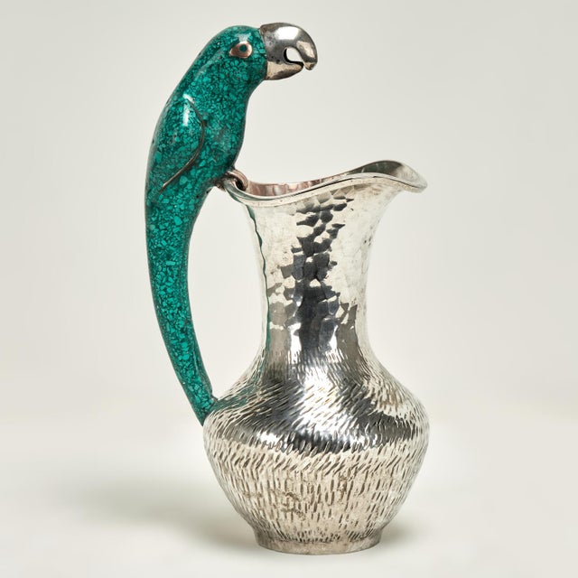 Standout vintage pitcher handcrafted in silver plate on hammered copper featuring a stone clad parrot as a handle....