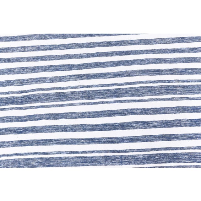 A crisp and timeless example of Indian flat-weave artistry, this vintage Dhurrie rug features a clean, nautical-inspired...