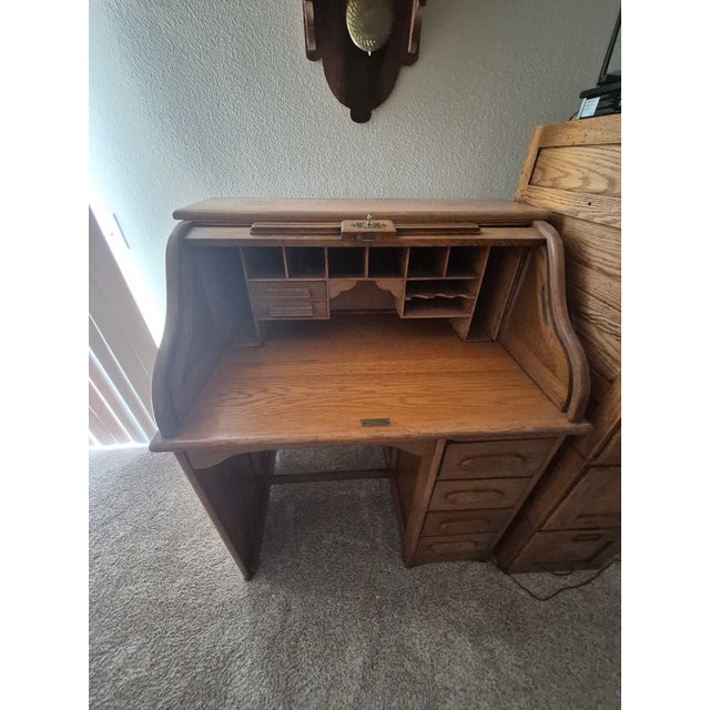 Often referred to as a children's roll top desk, this antique operates on an S-roll, single pedestal type with sliding...