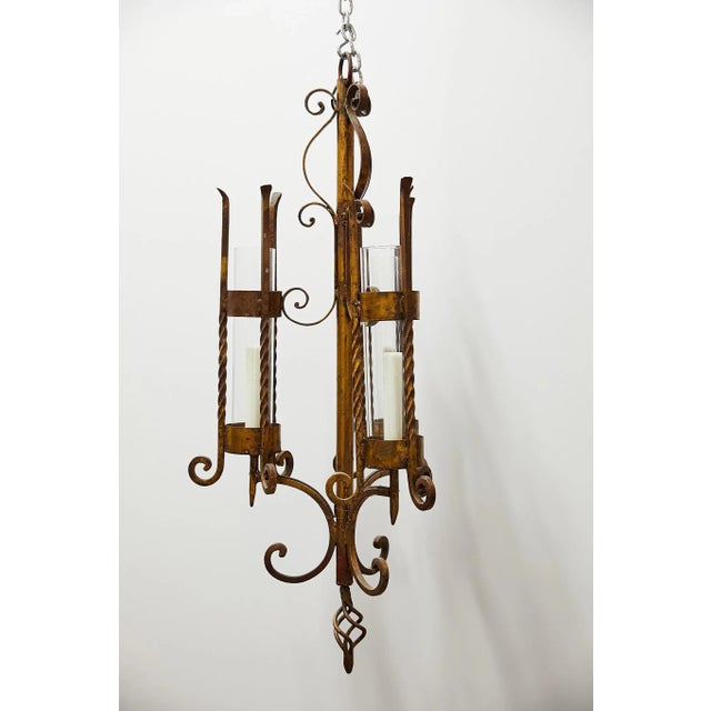 20th century Italian chandelier made of gilded wrought iron having three wired arms with twisted and scrolling candelabras...
