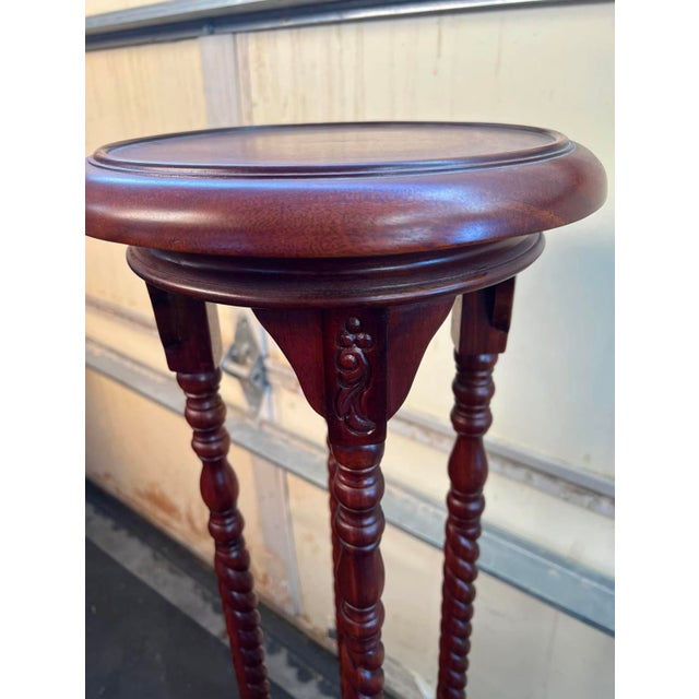 Beautiful wood plant stand with barley-twist legs, carved details, a round top, and a small lower shelf. Rich reddish-...