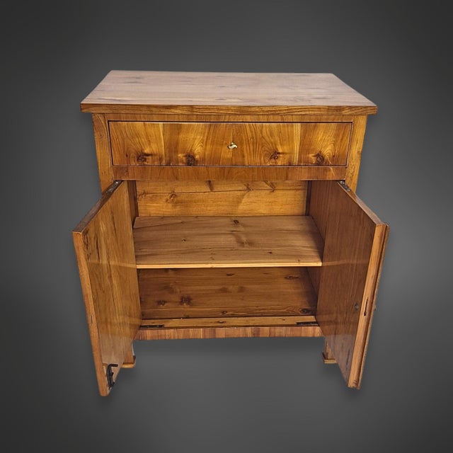 A two-door, pillared cabinet from the Biedermeier period, originating in southern Germany. The cabinet body is made of...