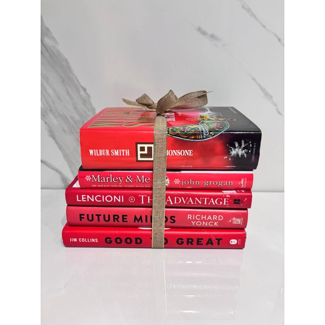 A collection of four red cover books, pre owned.