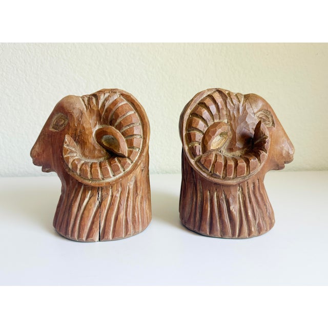 A pair of hand-carved wood ram's head or sheep's head sculptural bookends produced by Sarreid Ltd., made in Spain circa...