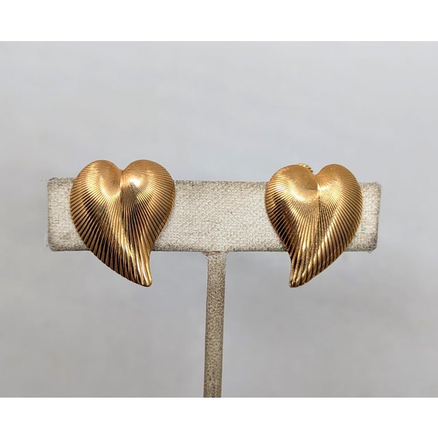 1982 goldtone ribbed heart clip and screw back earrings. Marked "NAPIER©" on the clips. Measure: 7/8 inches long by 3/4...