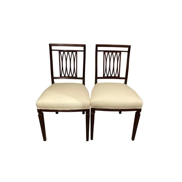 Consisting of eight side chairs, each with a rectangular back with trellis splats, upholstered seats raised on square...
