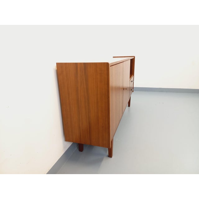 Vintage Scandinavian-style teak sideboard from the 1960s. Shallow design with ample storage: one open niche, two doors...