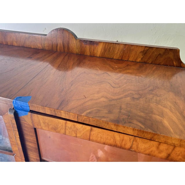 A rare original Art Deco display cabinet in richly figured walnut, circa 1930s. The dramatic swirling book-matched walnut...