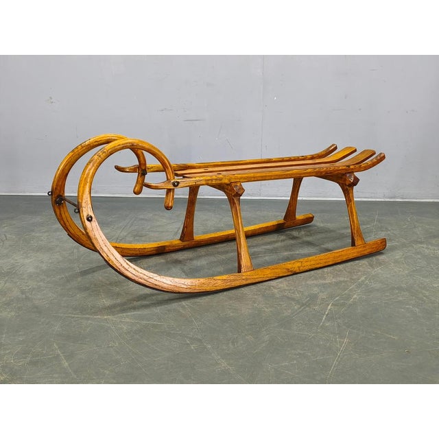 Original 1930s wooden sled from Czechoslovakia crafted in solid oak with iron fittings. This sculptural piece reflects...