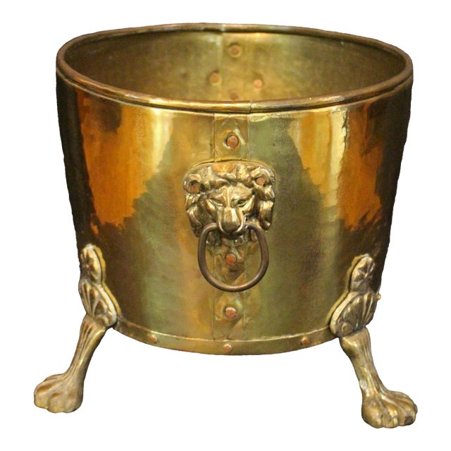 Circa 1880 oval brass jardiniere, English. Raised on large lion paw feet with lion mask ring handles. Riveted base &...