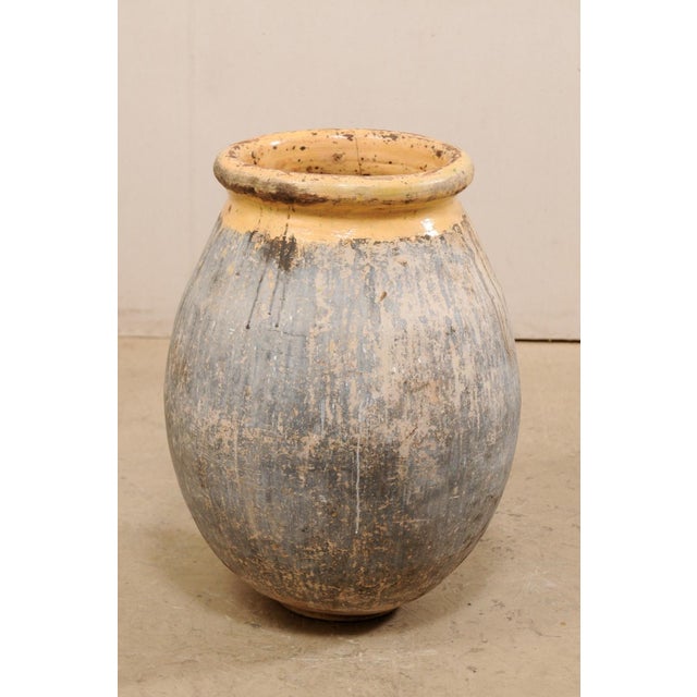 A French Biot jar from the early 20th century. This antique vessel from France features a mellow glazed and rolled rim &...