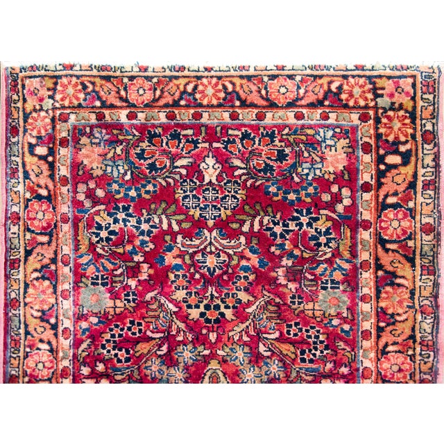 A wonderful early 20th century Persian Sarouk runner with an all-over mirrored floral pattern woven in traditional Sarouk...