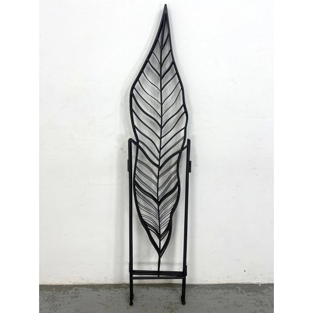 Three-panel folding room divider constructed from metal, featuring an openwork leaf-form design. Each panel is vertically...