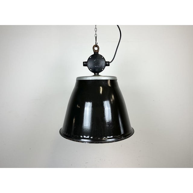 Industrial enamel hanging lamp made by Elektrosvit in former Czechoslovakia during the 1960s. It features a cast aluminium...