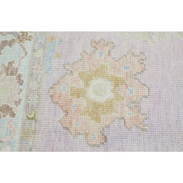 This modern Turkish Oushak rug is a stunning piece of art that has been handwoven using traditional techniques by skilled...