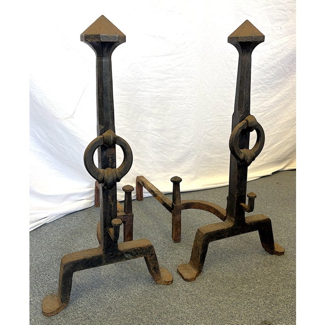 Large and stately pair of Addison Mizner andirons from the early 1900's. They are made of heavy hand forged wrought iron...
