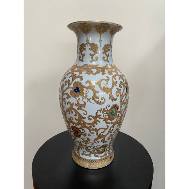 A 16-inch vintage Chinese porcelain vase featuring elaborate gilt lotus scrollwork and raised multicolor enamel accents...