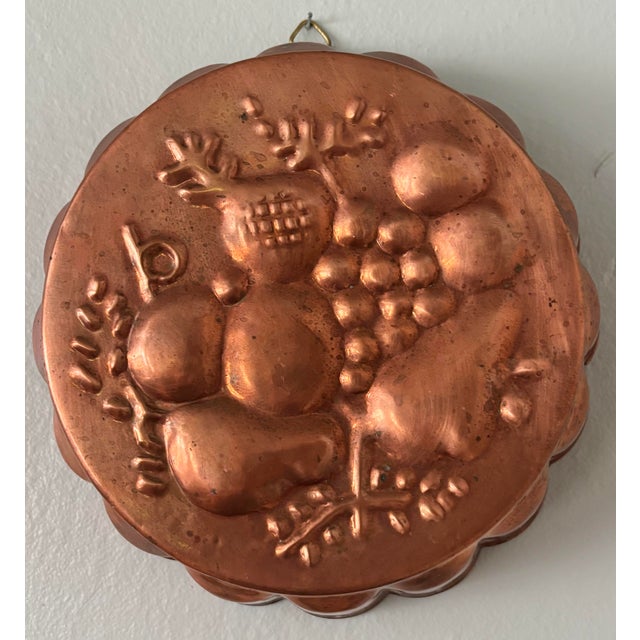 French Country copper jello mold with a relief of various fruits and with a hook for hanging. Reverse side has a tin...