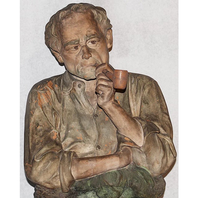 Striking figurine in this 19th century French painted terracotta of pipe-smoking Guluche Isle Adam farmer in repose by...