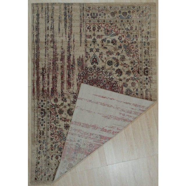 This machine made rug features a blend of wool and viscose, presented in a neutral color palette of ivory, beige, cream,...