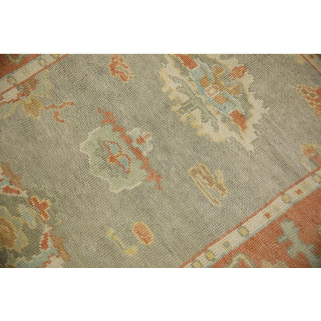 This modern Turkish Oushak rug is a stunning piece of art that has been handwoven using traditional techniques by skilled...