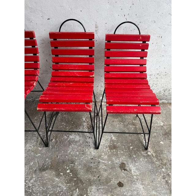 This eye-catching chair features a modern, industrial design with a bold red slatted seat and backrest, offering both...