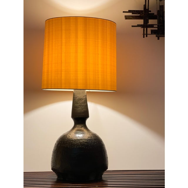 Large and sculptural table lamp signed by Swiss ceramist Mattli, dating from around 1970. Hammered textured black ceramic...