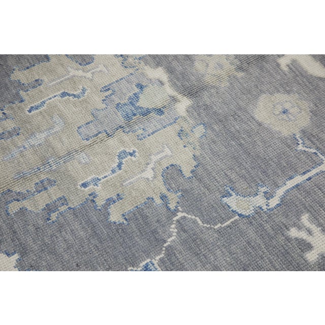 This modern Turkish Oushak rug is a stunning piece of art that has been handwoven using traditional techniques by skilled...