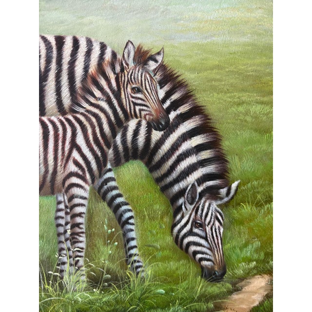 A finely executed original oil painting depicting a peaceful mother and child zebra grazing beside a river within a lush...