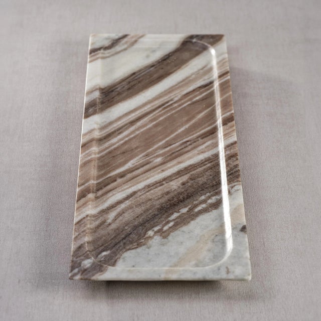 Crafted from premium marble, this tray features a unique rectangular silhouette with elegantly raised edges. The brown...