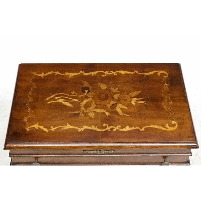 Antique Italian inlaid sewing table. Italy, early 20th century, having a rectangular hinged top with floral marquetry and...