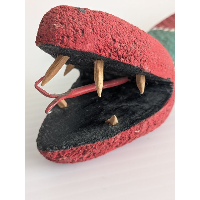 Whimsical, 1980's hand carved wooden folk art snake, painted in a banded green and red pattern and signed on the bottom by...
