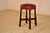 Charming 1920's pub stool from England. The seat is upholstered in what appears to be faux leather in a rich red color and...