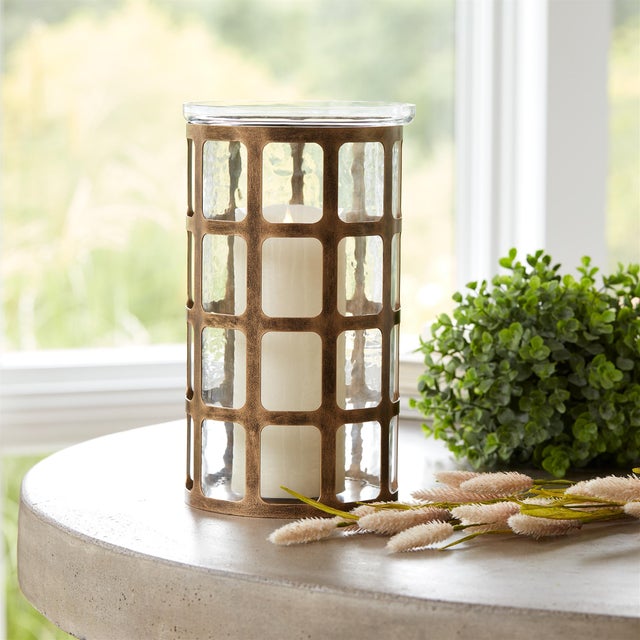 Add an elegant glow to your space with the Wavy Glass Hurricane Candle Holder. Featuring a unique abstract wavy glass...