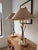 A beautiful pair of French brass and travertine arrow and tassel table lamps. Vintage fabric shades are included. Both...