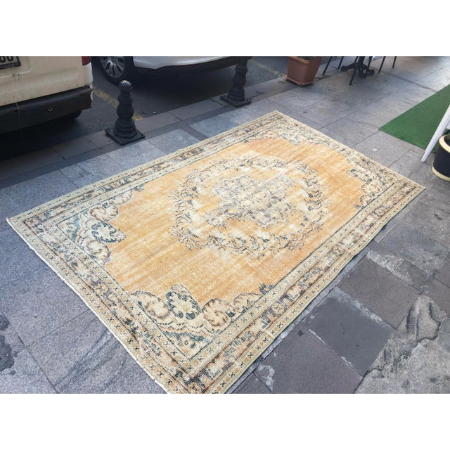 This is a vintage Turkish Oushak rug from the 1960s. The piece was hand-knotted.