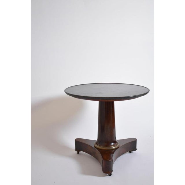 Mahogany pedestal table, XIXth c. Mahogany veneered round tea table, with a column leg on a tripod base, and a black...