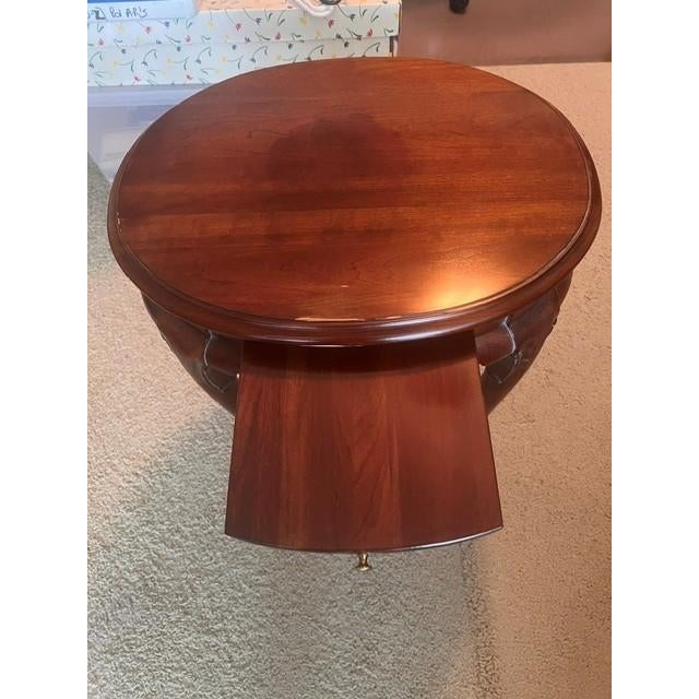 This is a traditional side table featuring a classic Queen Anne style, characterized by its graceful, curved cabriole legs...